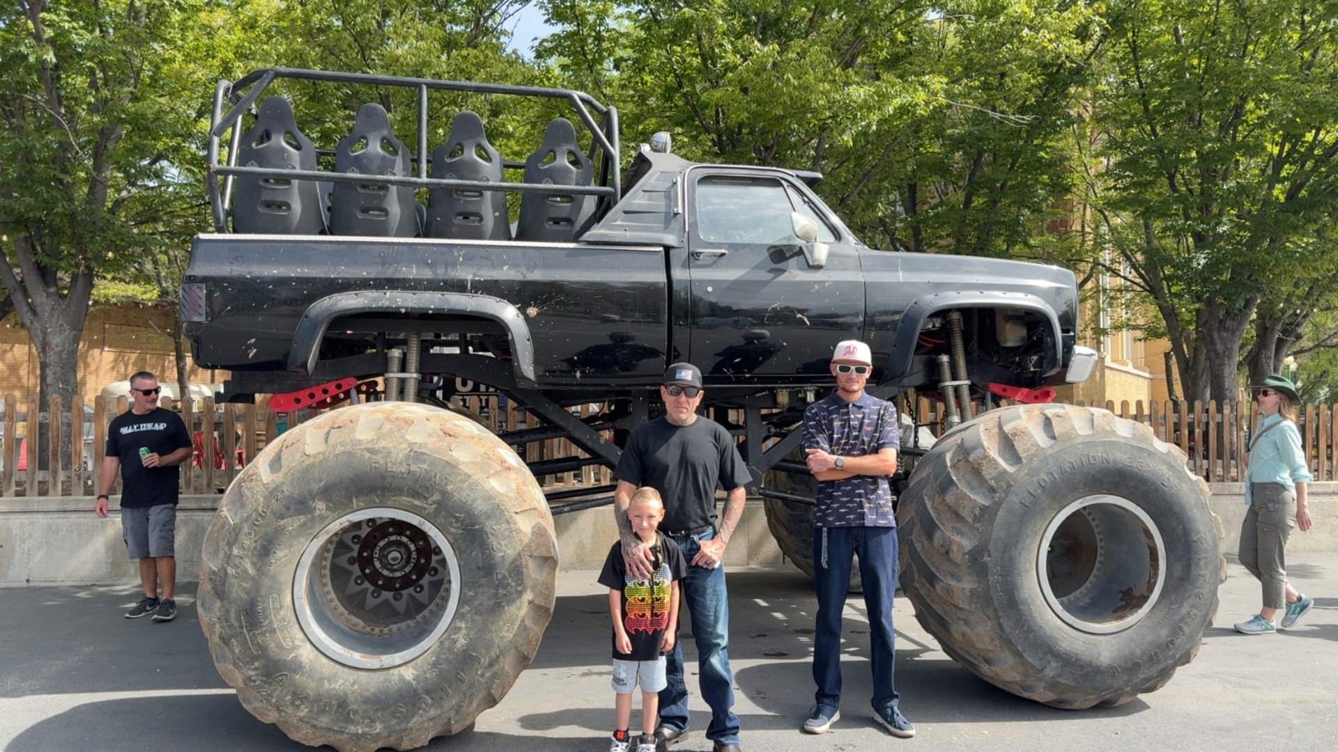 A Liberty Living client and caregivers posing in front of a monster truck at a community event