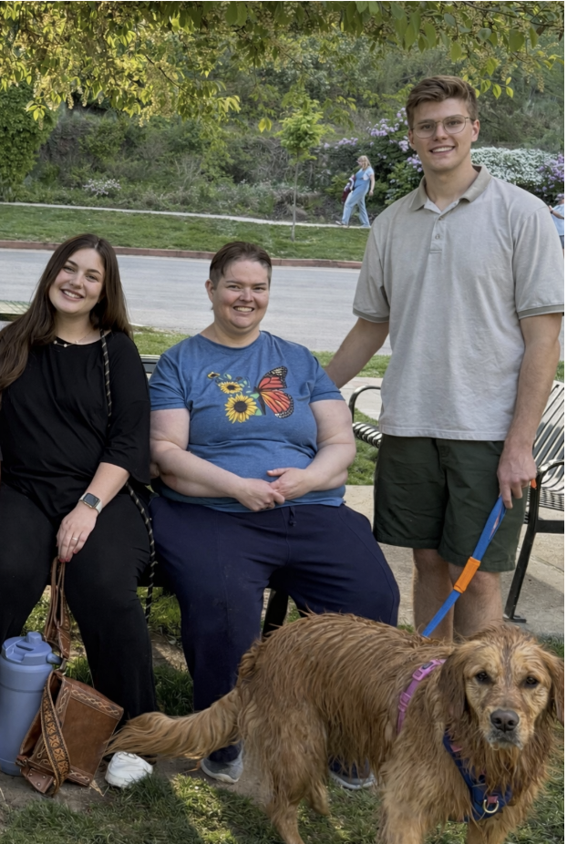 A Liberty Living client at the park with her caregiver and their golden retriever