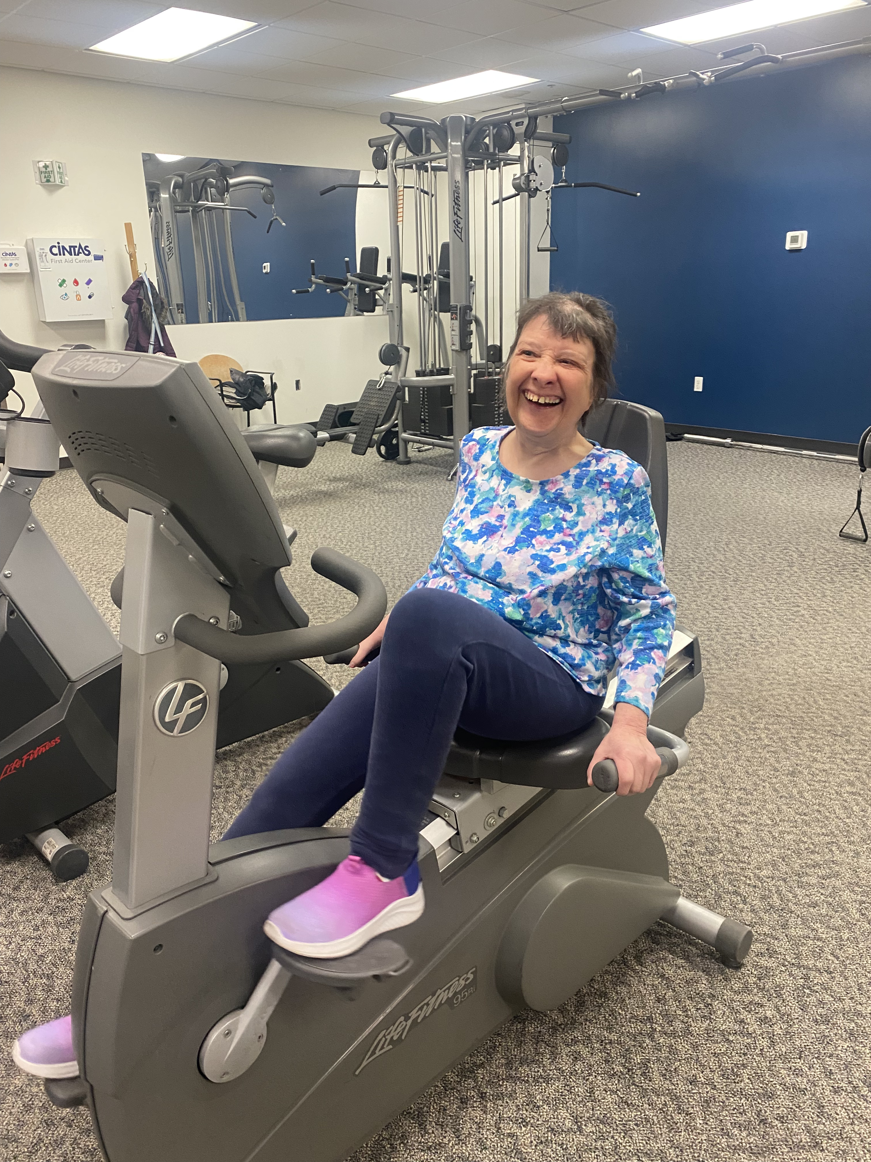 A Liberty Living client smiling while exercising at the gym
